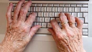 ältere Hände auf Computertastatur