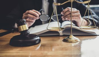 Un home amb vestit sosté el martell d'un jutge.