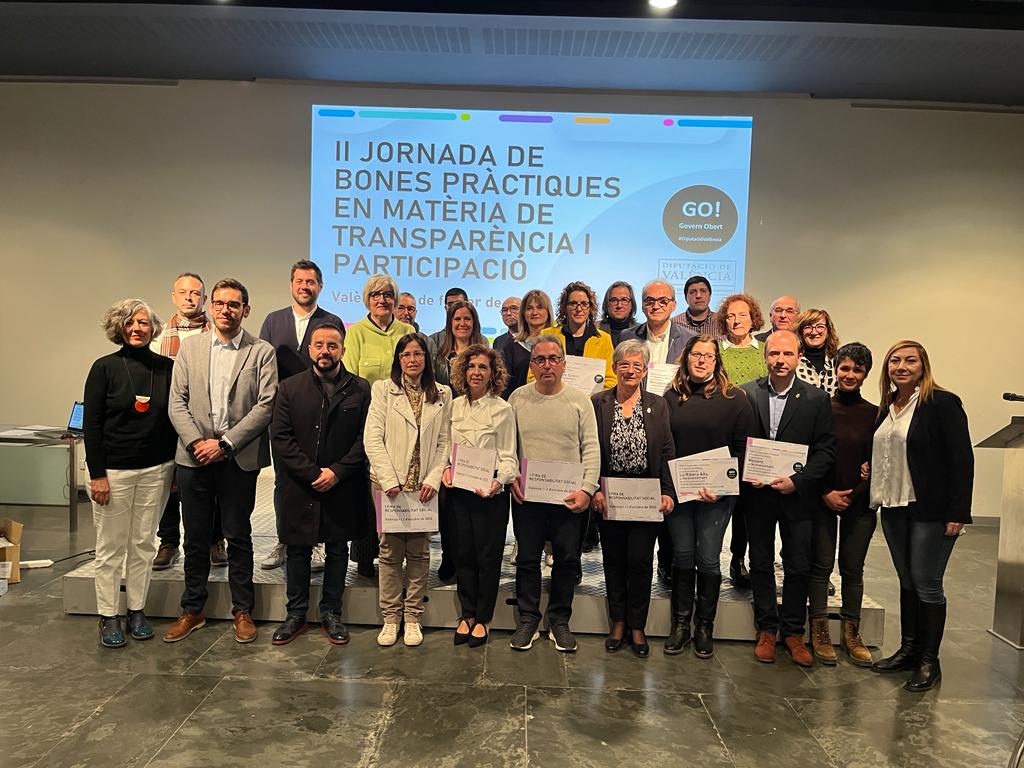 Un grupo de personas con certificados frente a una pantalla.